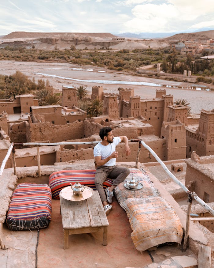 Man Sitting on Top of the Building While Looking the Overview